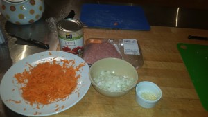 Ingredients for sloppy joes, grated carrots, onions, garlic, turkey & tomatoes