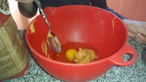 Mixing up peanut butter and eggs.